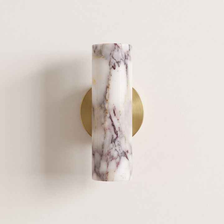 Calacatta Viola marble wall light with round brushed brass backplate, switched off, on a plaster wall