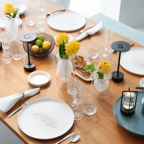 Two black cordless table lamps on a set dining table