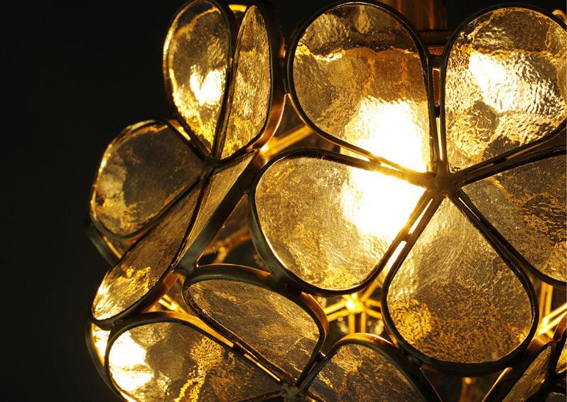 Close-up of warm-lit glass petals held in the brass cage