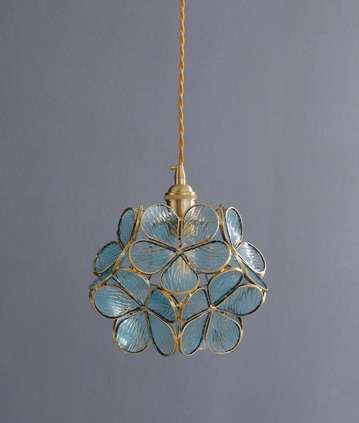 Glass Petal Pendant Light in blue tinted glass against a grey wall