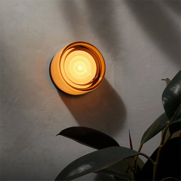 Amber Ripple Glass Surface Mount Light glowing with leaf shadows across the wall