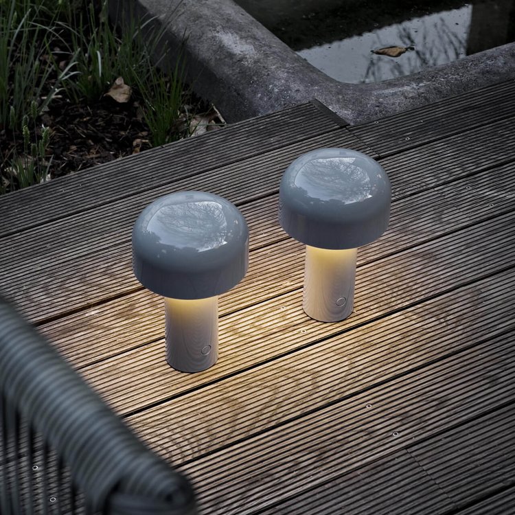 Two Agari cordless LED table lamps lit on a timber deck at dusk