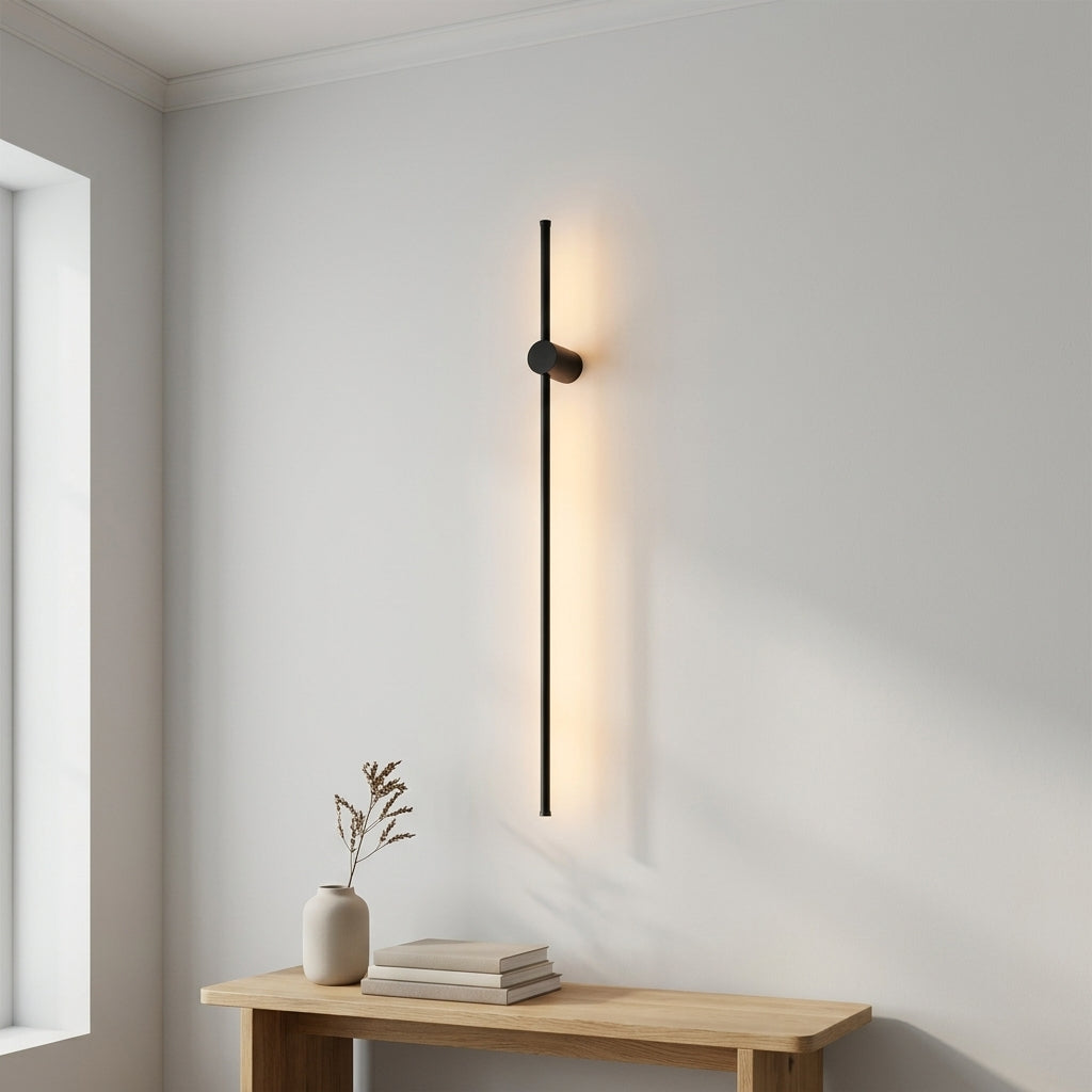 Contemporary Linear Wall Light in black, wall mounted with the fixing about a fifth of the way down the bar